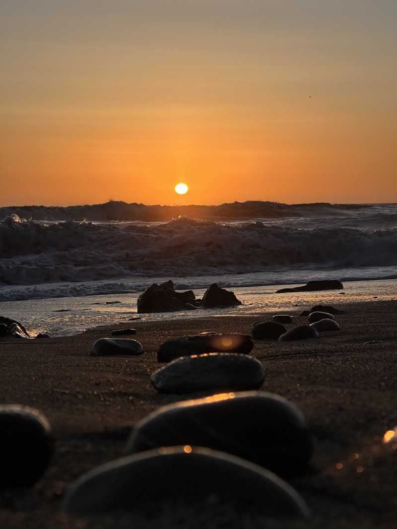 Sun setting over a rocky beach