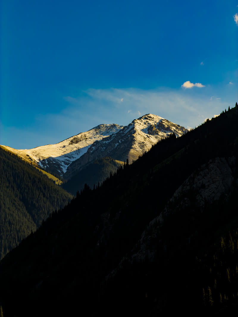 Sunlit mountain peak above a shaded valley